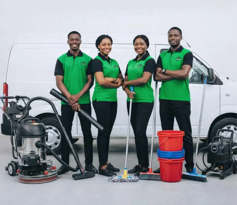 Four uniformed people with cleaning equipment in front of a PHILRONK-branded van.